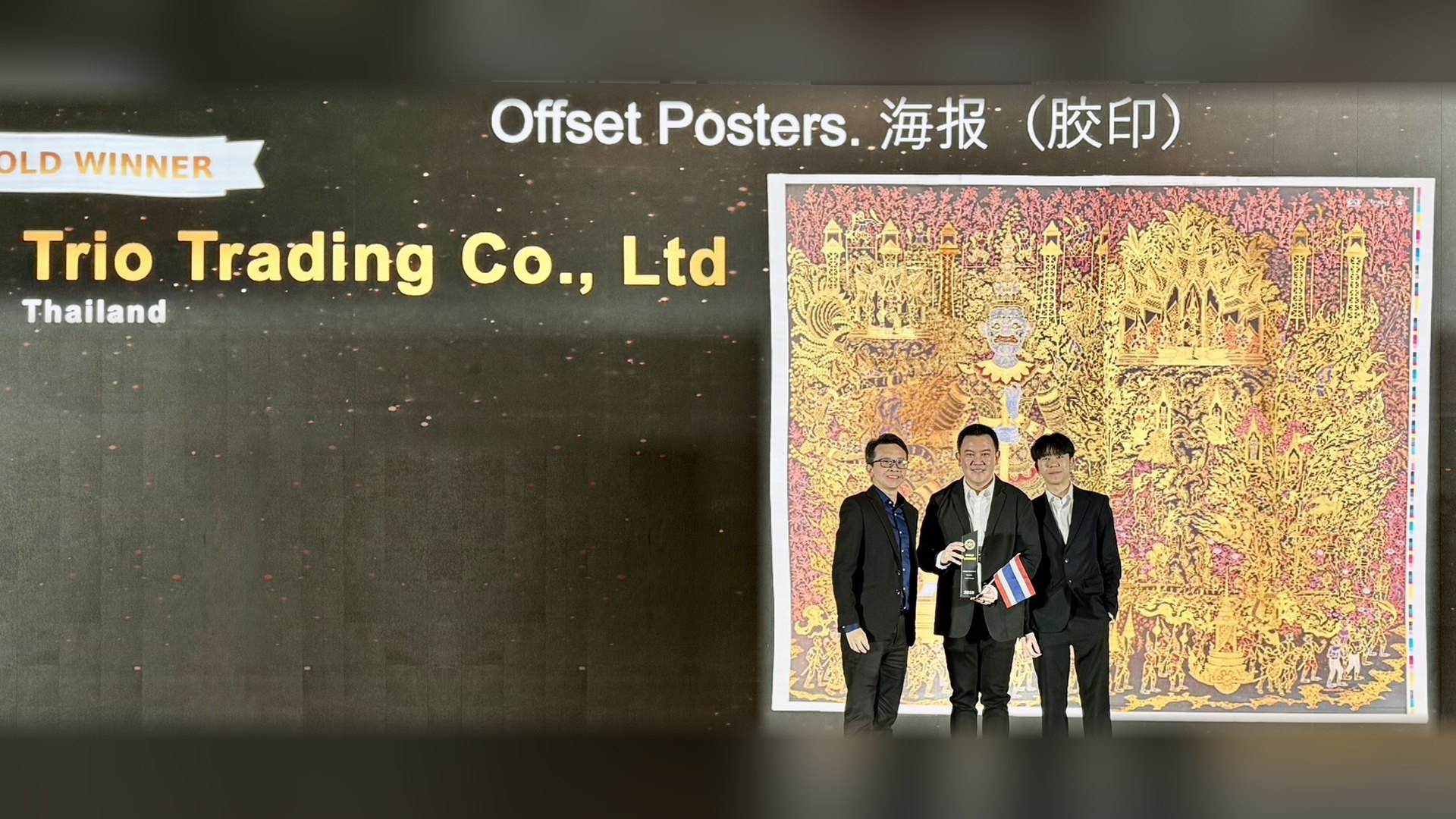 คุณพลพรรษ และคุณณัฐวัสส สุวรรณพิมลกุล จาก Trio Trading รับรางวัล Gold Winner หมวด Offset Posters จากเวที Asian Print Awards 2026 ข้างผลงาน The Royal Coronation Ceremony from Indra 3